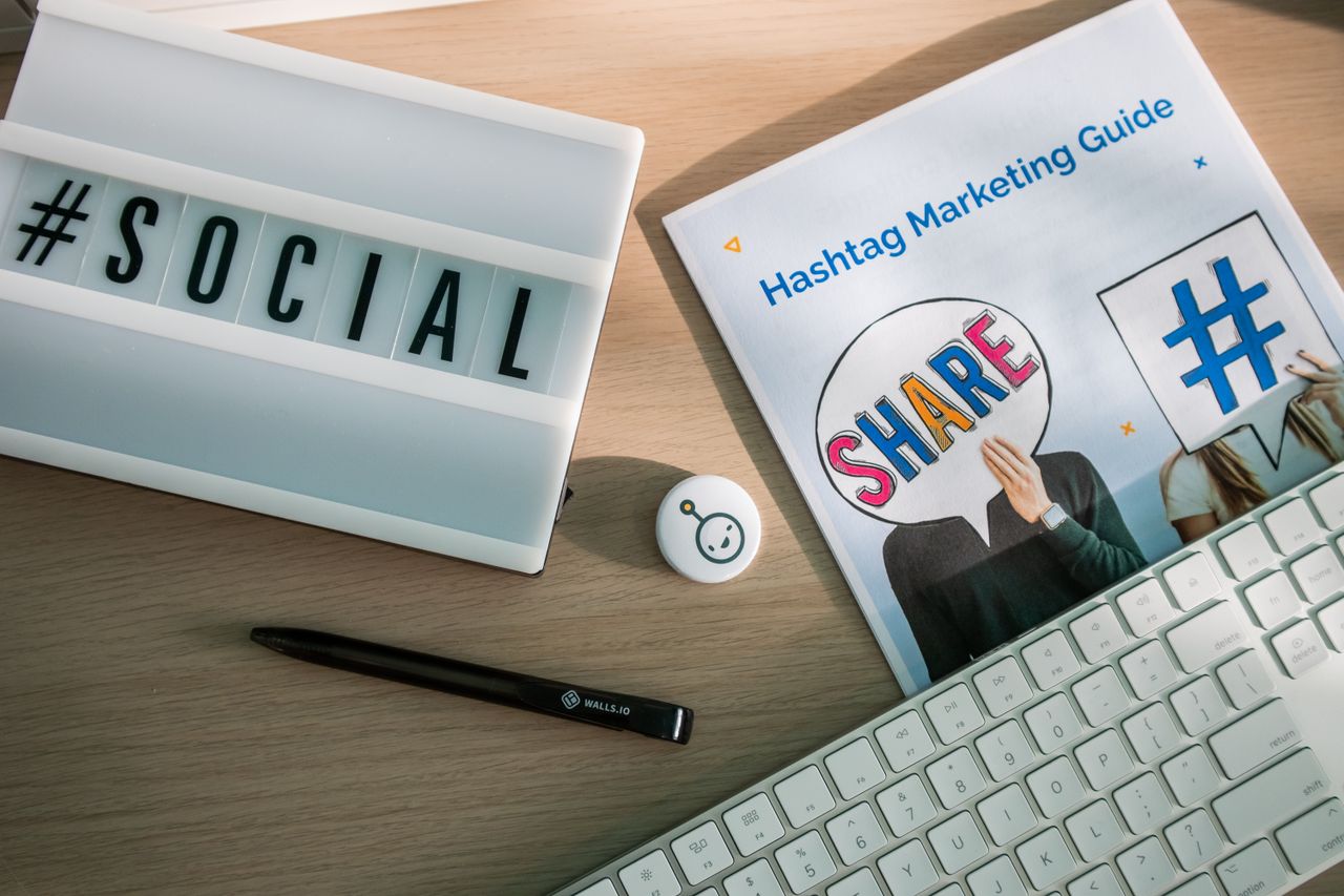 A desktop arrangement featuring social media marketing essentials, including a keyboard, a lightbox, and a guide.